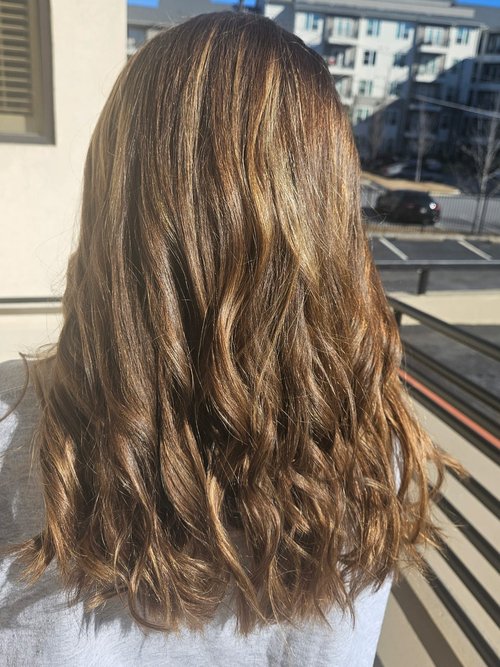 A woman's hair after Addi gave a balayage and beach wave style.